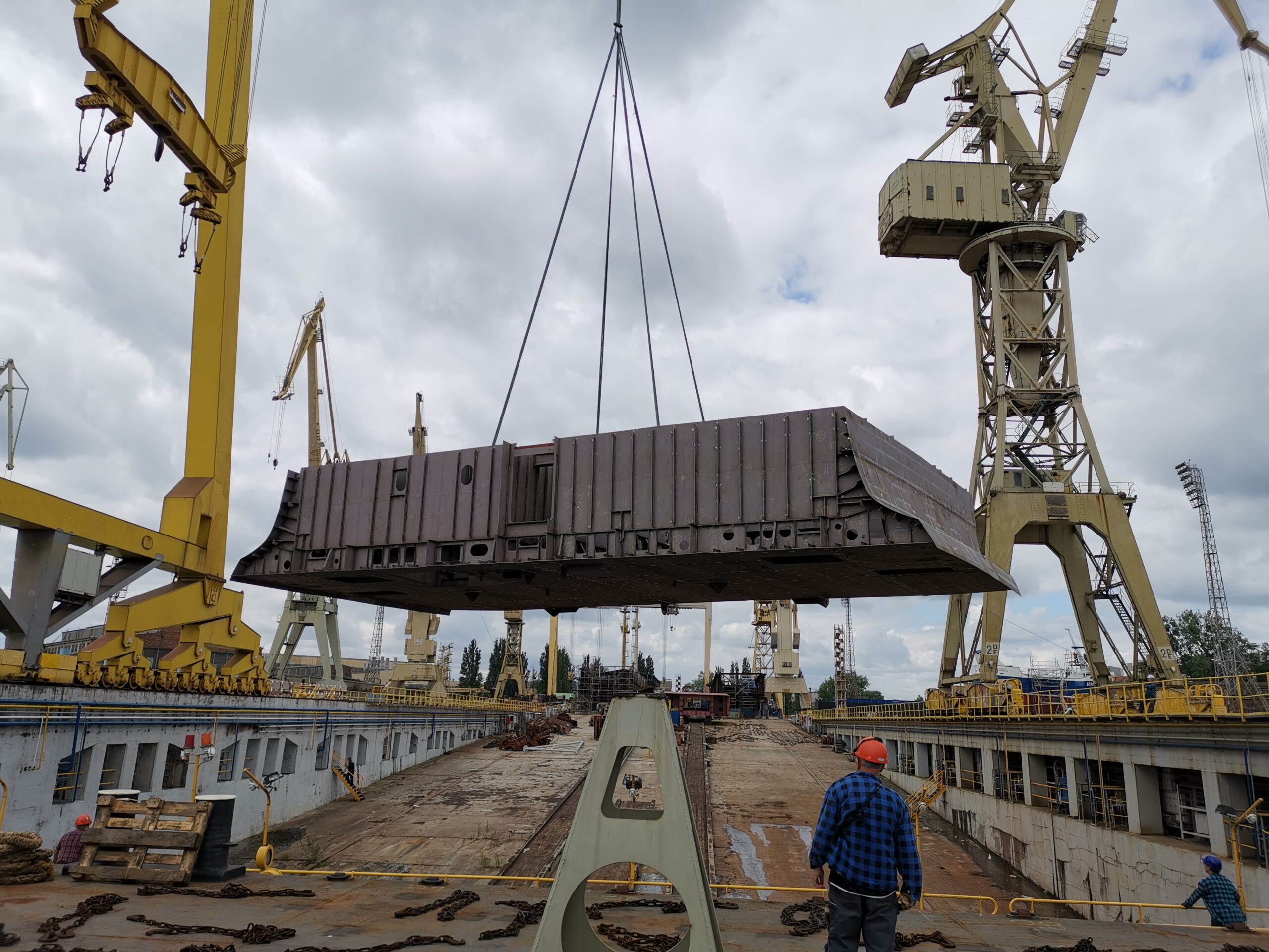 Rohbausegment eines Kreuzfahrtschiffes wird von einem Kran angehoben